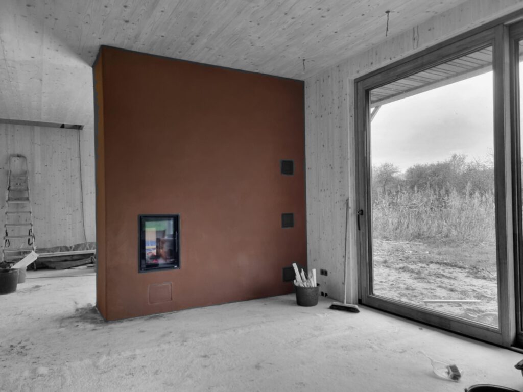 Leemkachel warmtewand met basisleem leemstuc afwerking in CLT woning